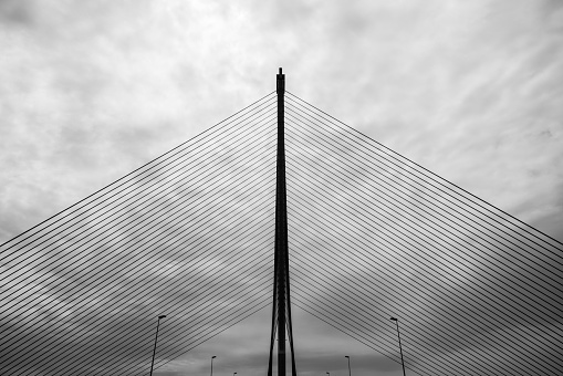 Silhouette of the infamous cable-stayed bridge in Talavera de la Reina over the river Tagus against a cloudy sky, one of the symbols of the construction bubble in Spain. At 192 meters, it is the highest bridge in Spain and the second highest in Europe. Toned.