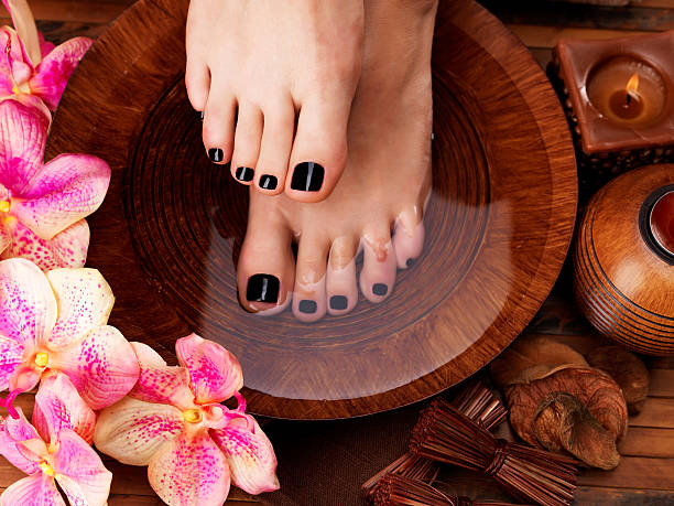 istock Beautiful women legs with black pedicure after Spa procedures 524890854