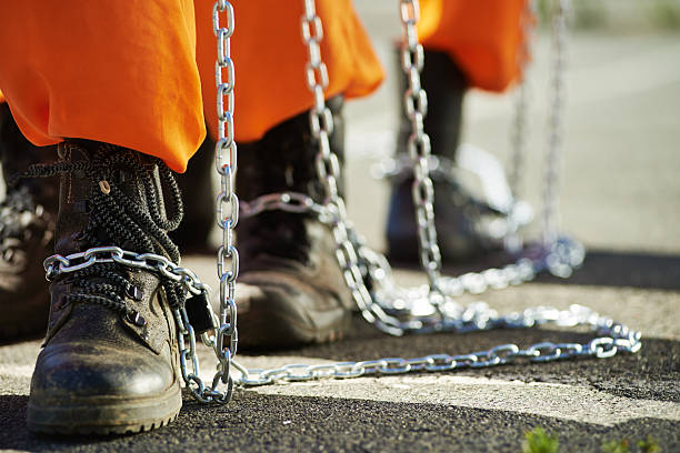 Slavery Close-up of male feet in chains gang stock pictures, royalty-free photos & images