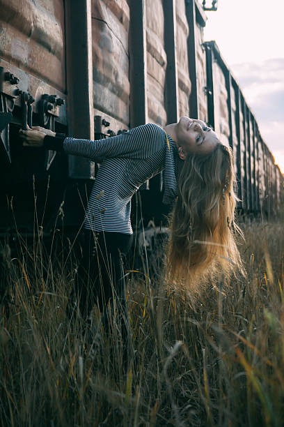 istock Young woman walking on railway tracks near train 524891912