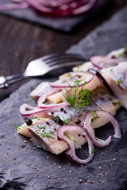 istock Sliced herring on a black slate plate 524895484