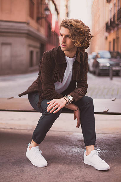 istock Cheerful young man relaxing outdoors on city bench 524895520