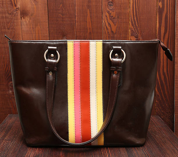istock Woman's leathure brown handbag on wooden background 524895618