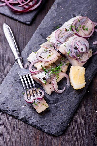 istock Sliced herring on a black slate plate 524895650
