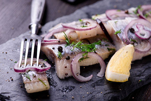 Scheiben Hering auf eine schwarze Tafel-Platte – Foto