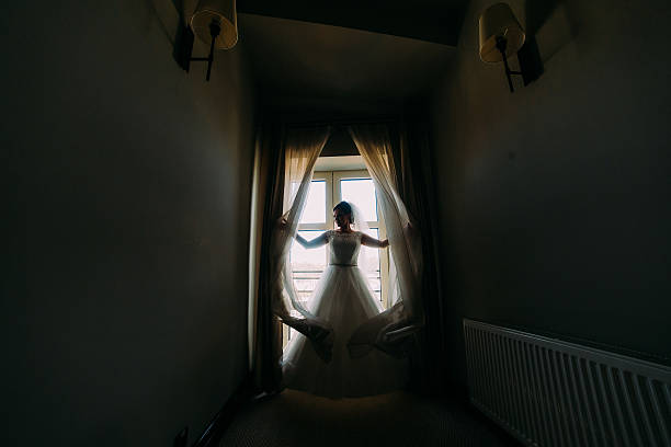 istock Brides silhouette on the background of a window with curtains 524896136