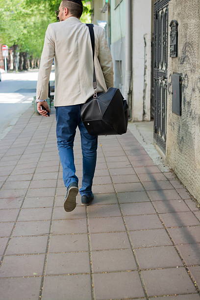 istock Handsome businessman is walking at the street 524896312