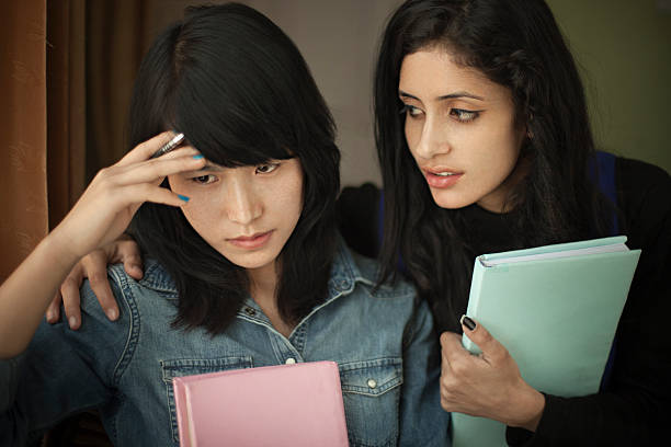 istock Late teen student consoling to a depressed friend while studying. 524896660