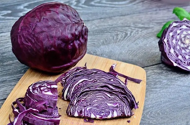 part of red cabbage on gray wooden table