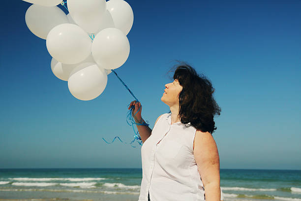 istock woman holding white balloons 524899168