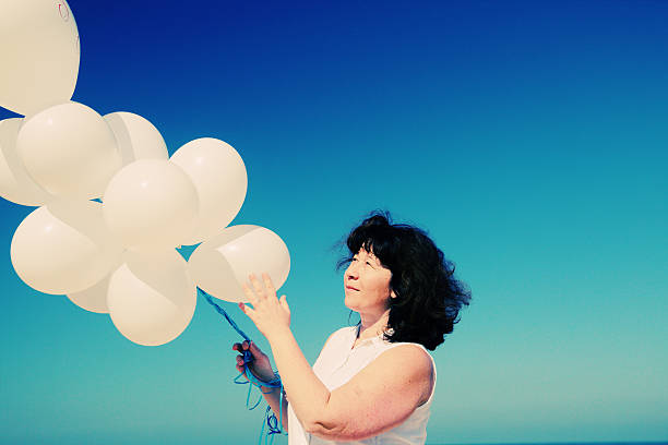 istock woman holding white balloons 524899284