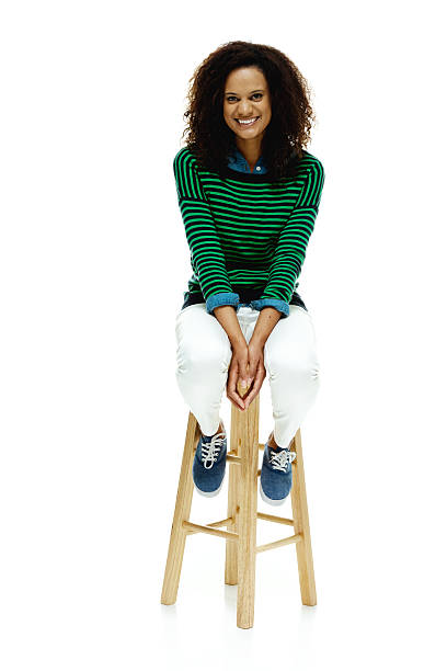 istock Cheerful woman sitting on stool & looking at camera 524901165