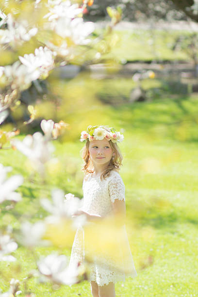 biondo ragazza e un albero di magnolia - formal garden ornamental garden child single flower foto e immagini stock
