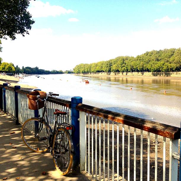bike on the riverside an old fashioned bike is left by its owner on the river side - its a sunny, lazy day putney photos stock pictures, royalty-free photos & images