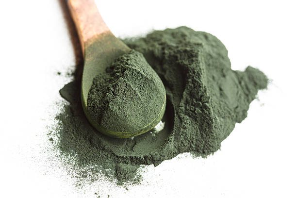 alga spirulina pó na colher de pau - chlorella spirulina bacterium algae nutritional supplement imagens e fotografias de stock