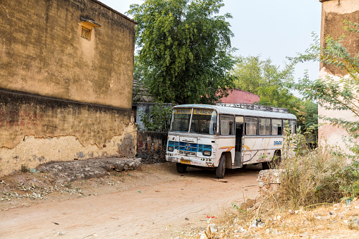 Alsisar, India - December 1, 2015: An old Tata bus stands on the road in the suburbs of the village Alsisar. Alsisar is a small town with an approximate population of 5000 to 5500 in the north-western part of Jhunjhunu district, Rajasthan, India. Alsisar is surrounded by semi desert.