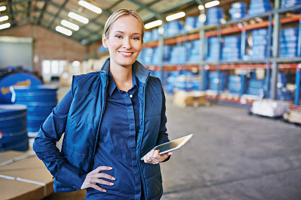 Tracking your order to its destination Shot of a woman using a digital tablet in a large warehousehttp://195.154.178.81/DATA/i_collage/pi/shoots/784458.jpg blue collar worker stock pictures, royalty-free photos & images
