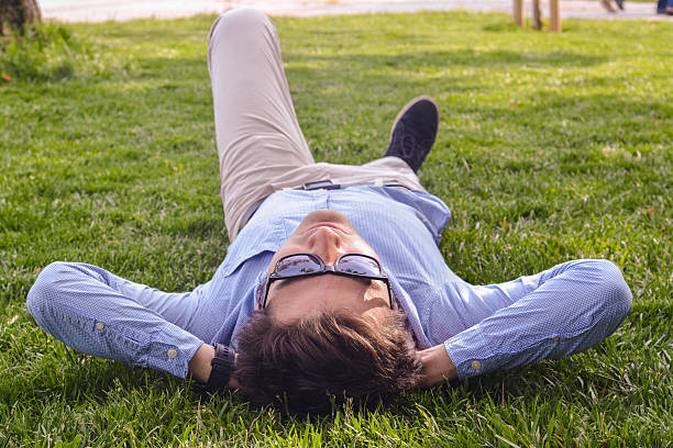 istock Businessman lie down on the grass ground 524904881