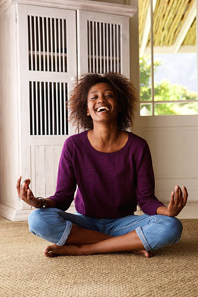 istock Smiling young black woman sitting on floor practising yoga 524905034