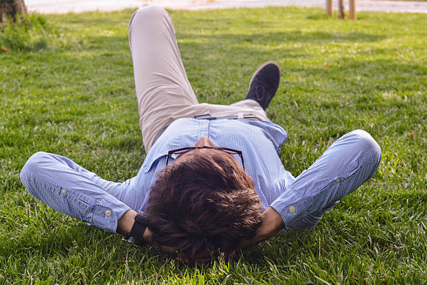 istock Businessman lie down on the grass ground 524905177