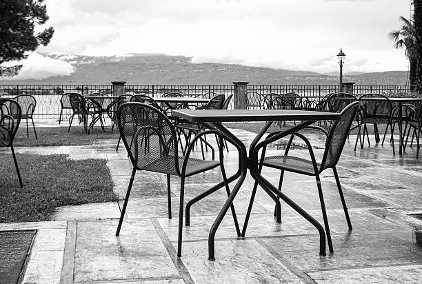 stacked chairs on the veranda of the cafe on a rainy day