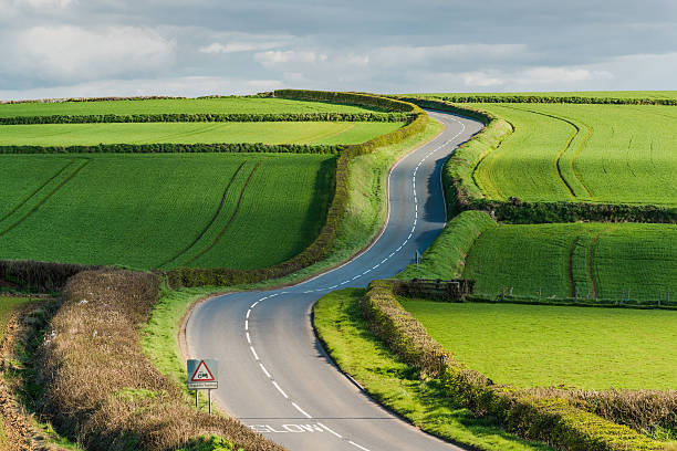 Rural road on rolling hills in countryside stock photo