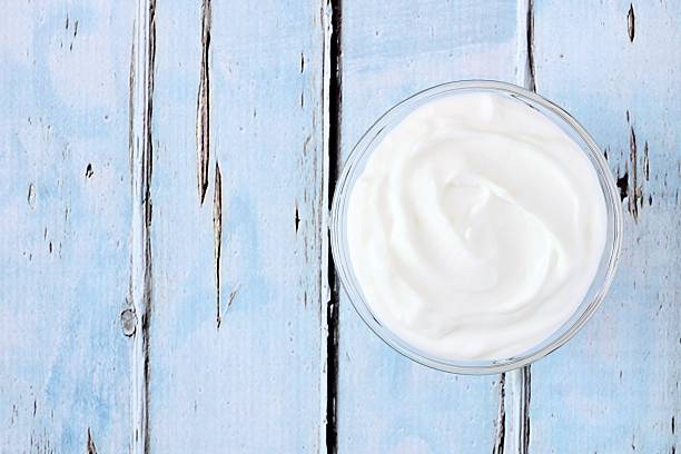 istock Greek yogurt, downward view on rustic blue wood 524906758