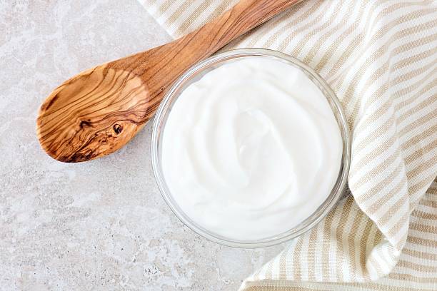 istock Greek yogurt, with cloth and spoon on white marble 524906818
