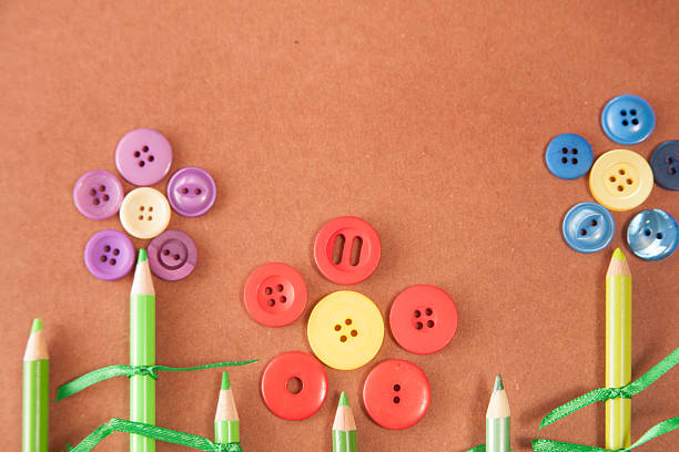 istock Red, blue, purple buttons and green pencils flower craft. 524907038