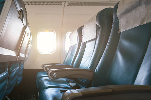Interior of airplane with empty seats and sunlight at the Interior of airplane with empty seats and sunlight at the window. Travel concept. seat stock pictures, royalty-free photos & images