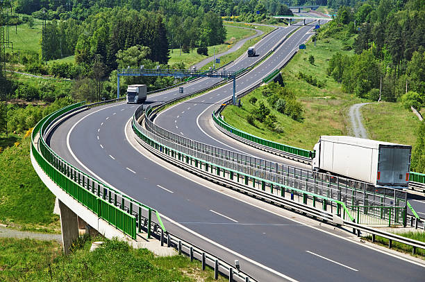 istock The highway between woods, electronic toll gates, three moving trucks 524908501