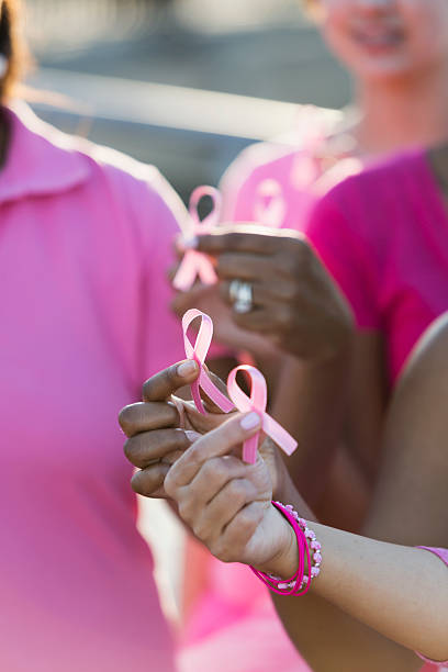 istock Multiracial hands holding breast cancer awareness ribbon 524911432