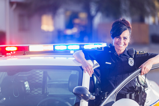 Mujer policía socorrista de pie al lado de coches photo