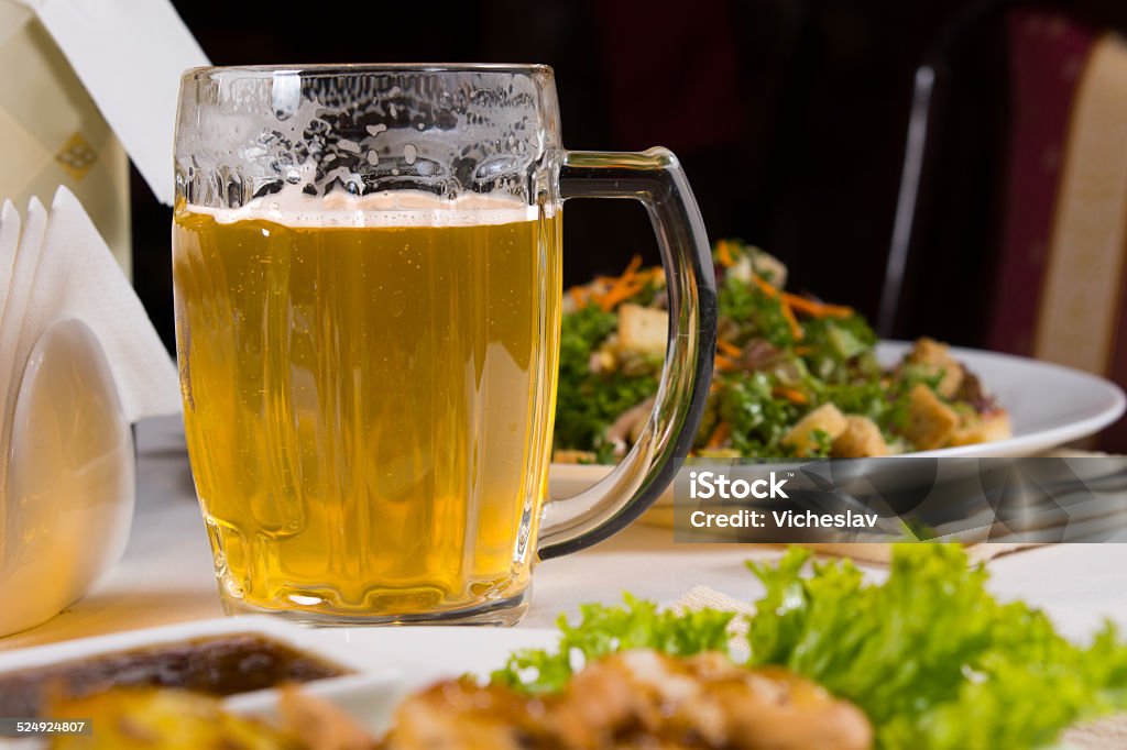 Mug Beer on Table Amongst Plates of Food Glass Mug of Beer on Table Amongst Plates of Food on Table in Restaurant Affectionate Stock Photo