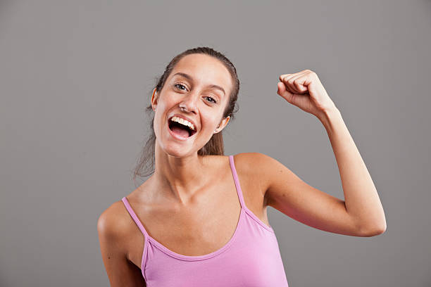 istock winning girl raising up her arm happily 524927209