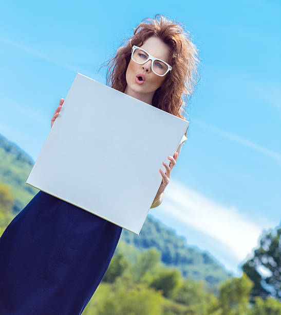 istock Expressive funny woman holding white board 524927381