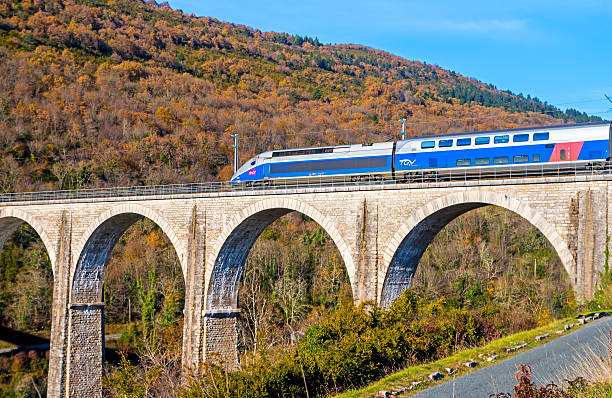 French TGV on viaduct in Rhone-Alpes France Cize, France - November 20, 2014: French high speed train TGV operated by SNCF, national rail operator on Cize-Bolozon viaduct in Ain, Rhone-Alpes region in France. This train was developed during the 1970s by GEC-Alsthom and SNCF. A TGV test train set the record for the fastest wheeled train, reaching 574.8 km/h (357.2 mph) on 3 April 2007. ain france photos stock pictures, royalty-free photos & images