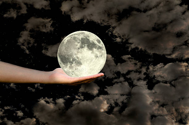 istock moon in a hand against the sky 524943013