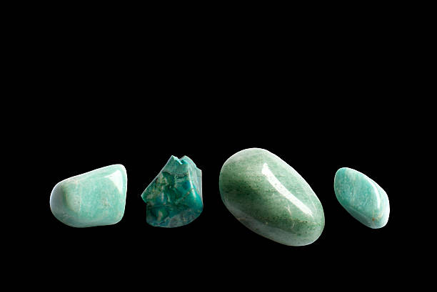 Four green stones Four green stones. Four green semi-precious gemstones, aventurine, azurite, turquoise, isolated on black feldspar stock pictures, royalty-free photos & images