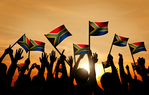 Grupo de personas, agitando South banderas africanas en Contraluz photo