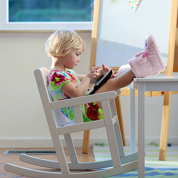 istock Little girl playing with tablet PC at home 524945839