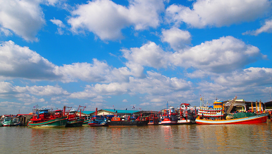 Colorful fishing boats at the pier on sunny clear sky in Thailand, Southeast Asia.