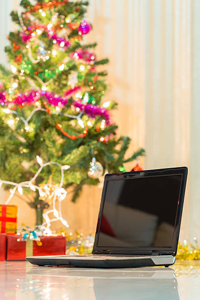 istock laptop with gift box and christmas lights background 524948221
