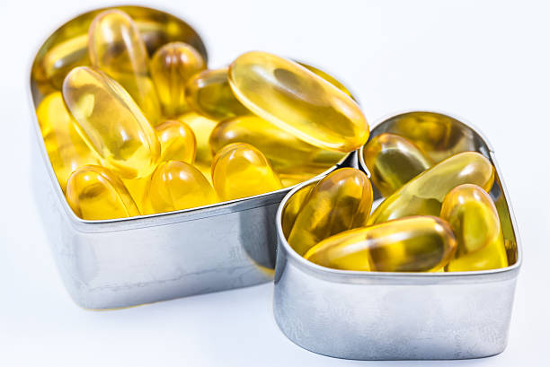 istock Two fish oil pills in heart shape box isolated 524997551
