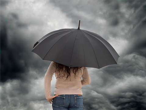 woman with umbrella standing in the rain