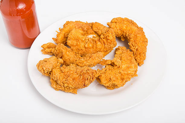 Chicken Strips on White Plate with Hot Sauce stock photo