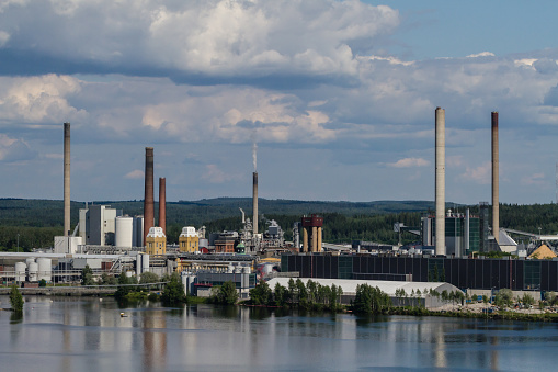 External overview of a paper factory, forest industry facility with multiple smokestacks