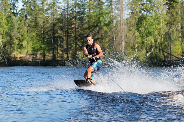 istock Young man riding wakeboard on a summer lake 525013480