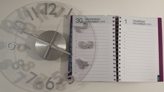 Clock with open daily planner.
