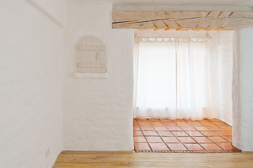 Empty Rustic Room with White Adobe Brick Wall and Tiles
